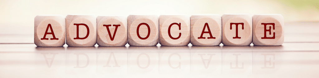 Small wooden blocks, each with a letter on it, spelling the word "ADVOCATE".